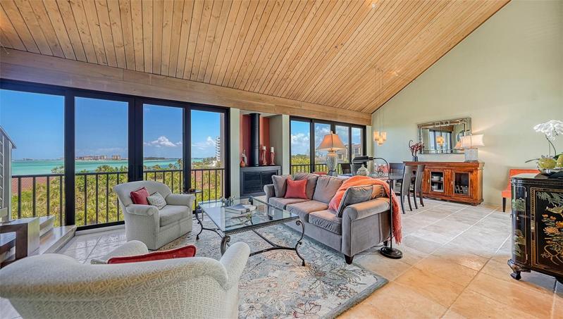 Walls of impact glass sliding doors to Gulf views looking over Big Pass to  Lido Key