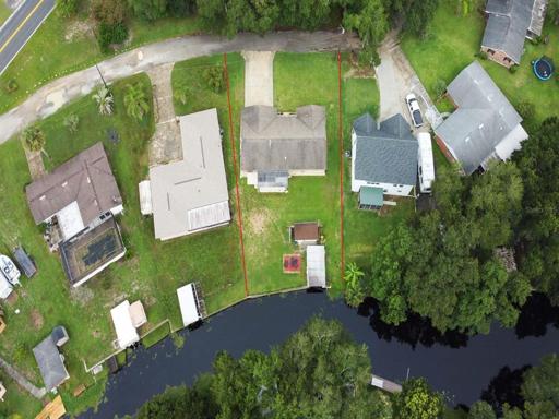 Aerial view of lot showcasing the back yard patio, shed and boat house
