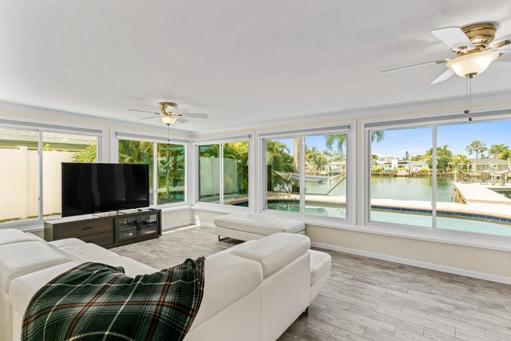 Enclosed Florida room looking pool, dock, and canal