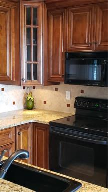 upgraded kitchen with wood cabinetry and granite