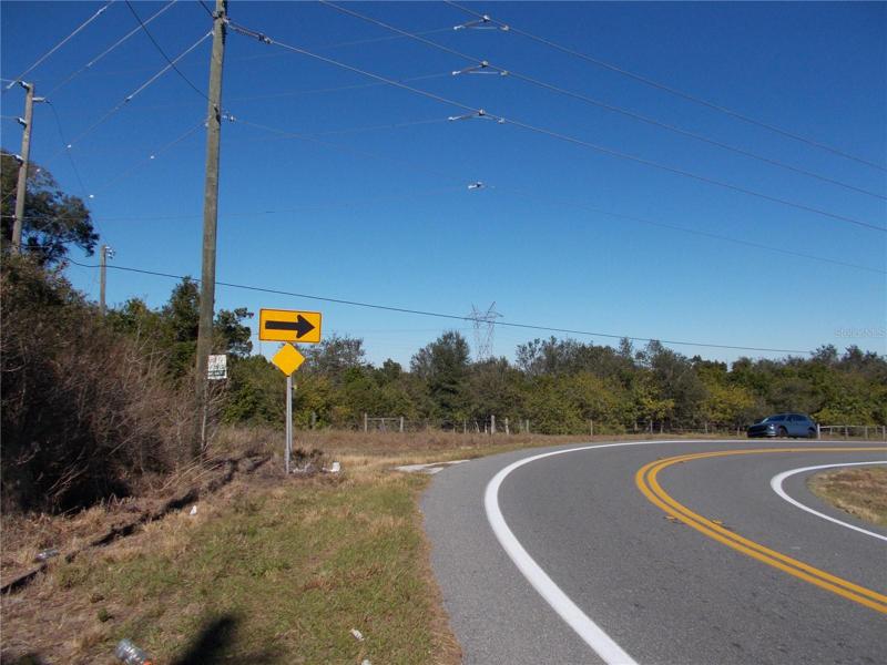 See the electric pole and the yellow arrow to the right there is the easement road exactly at the curve, grassy area.