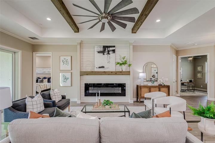 Great Room with tray ceiling, Decorative Beams & Gorgeous Fireplace