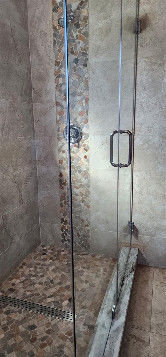 GLASS DOORS IN THIS LARGE MASTER BATHROOM SHOWER
