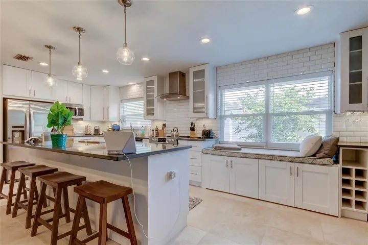 Recessed lights, pendant lights, and under cabinet lighting makes the kitchen a highlight