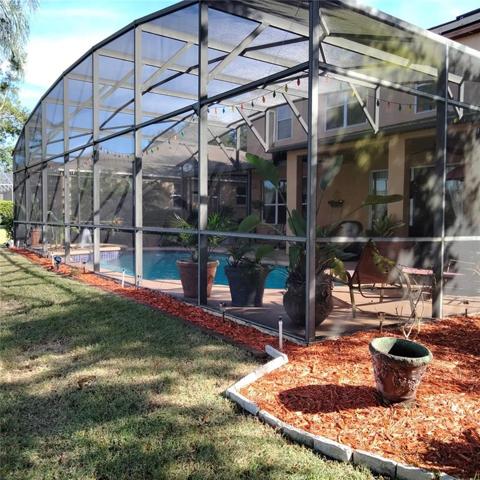 View of the back of the screened-in pool from the left hand side of the home.