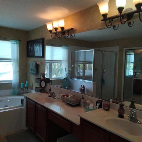 The Master bedroom has a jetted roman tub and double sinks. one raised higher than the other with a huge mirror reflecting a beautiful view of the pond