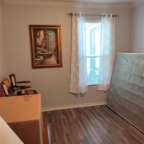 First Floor bedroom with laminate flooring and large window with view of the pond in the back of the house