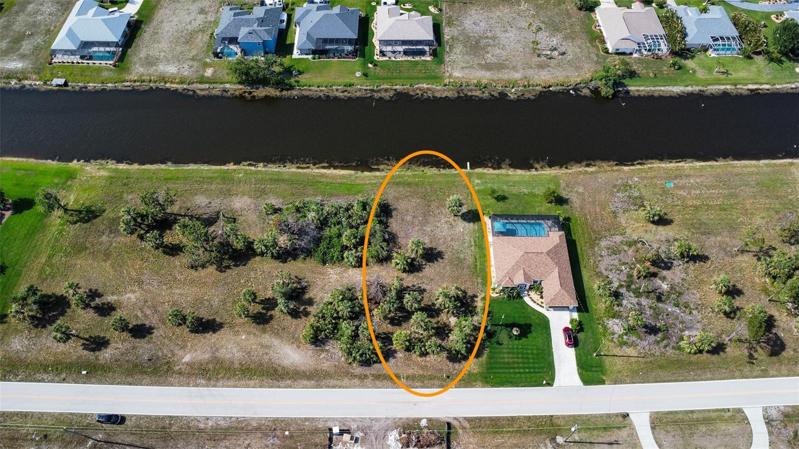 Canal front lot, sparsely wooded. 