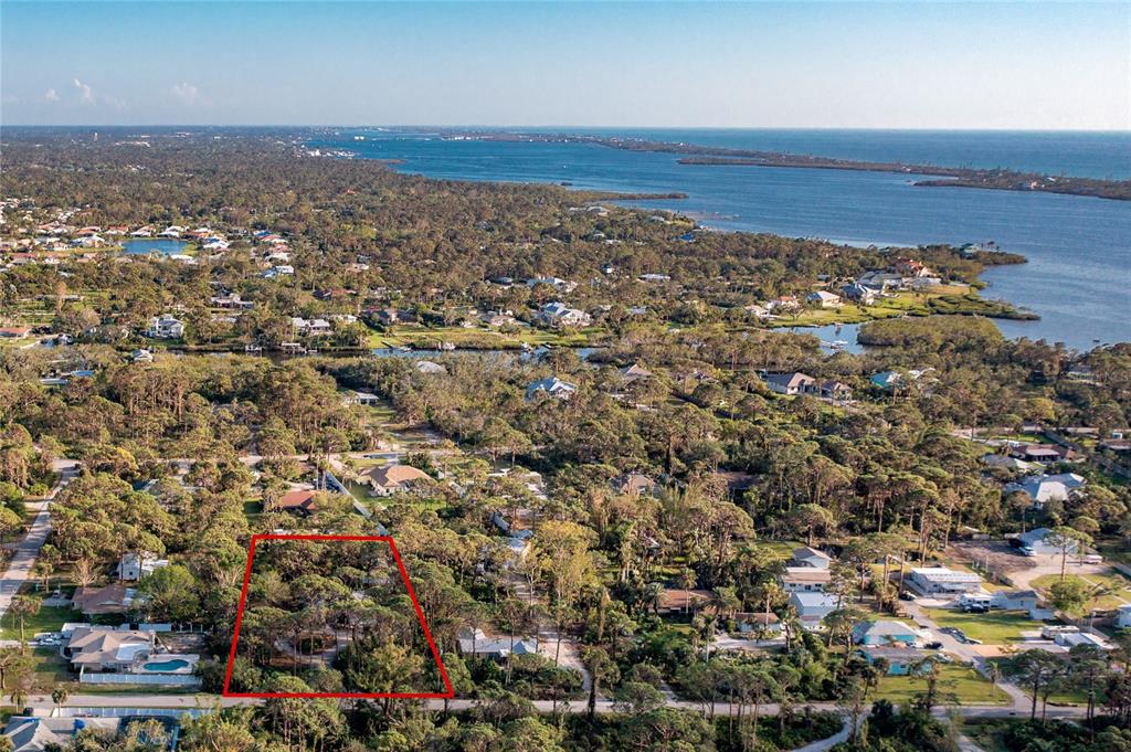 The back view of the home shows the screened lanai and private wooded lot.