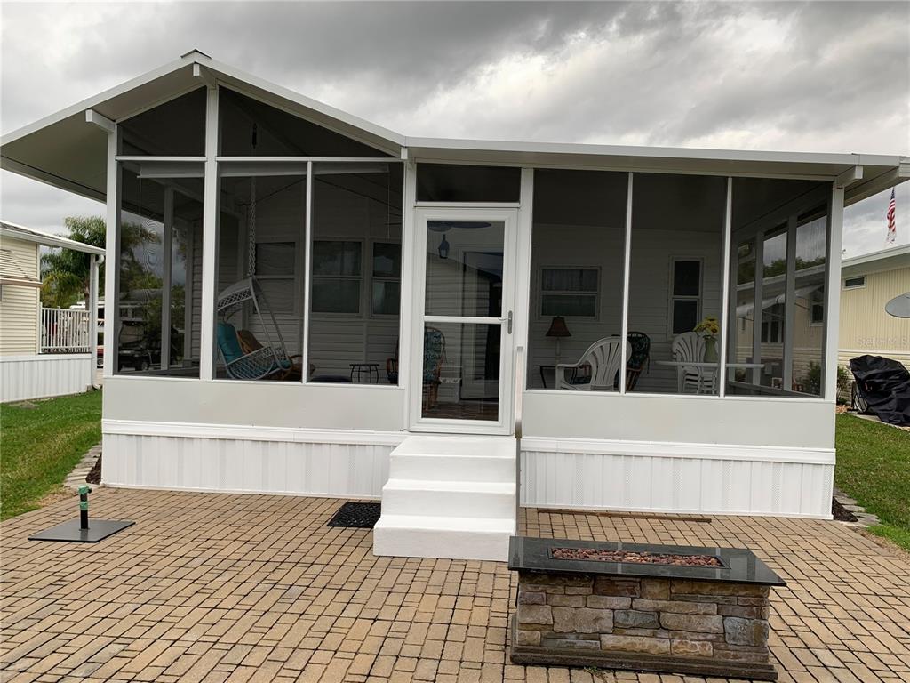 Exterior view of new back porch &amp; pavers with propane firepit.