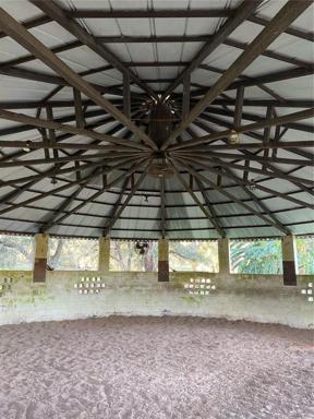 Inside round pen with steel trusses and metal roofing