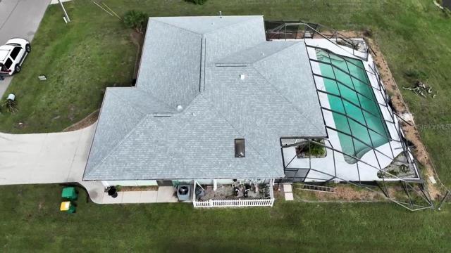 Aerial of finished roof, installed 12/2022. Note pool cage is damaged, but under contract to be replaced.