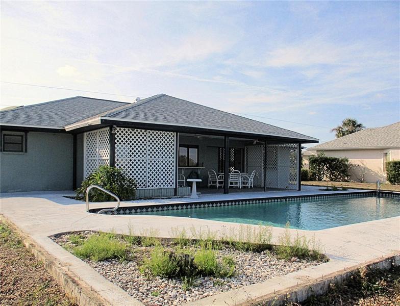 Back of home with pool.  Contract to replace pool cage in place.