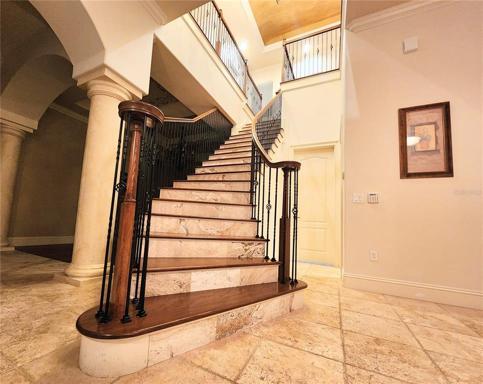 Grand Staircase. Wood Steps, Tile Risers, Wood Rails with Wrought Iron Spindles