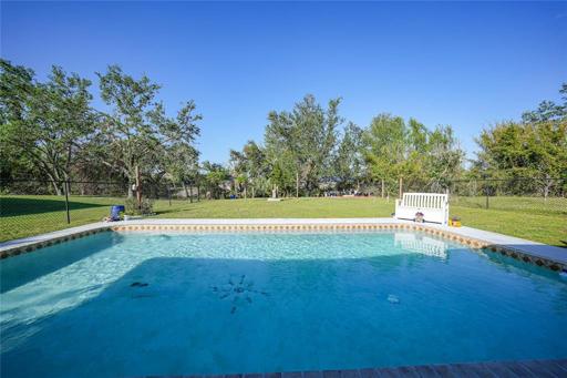 Pool with view of back yard to freshwater canal