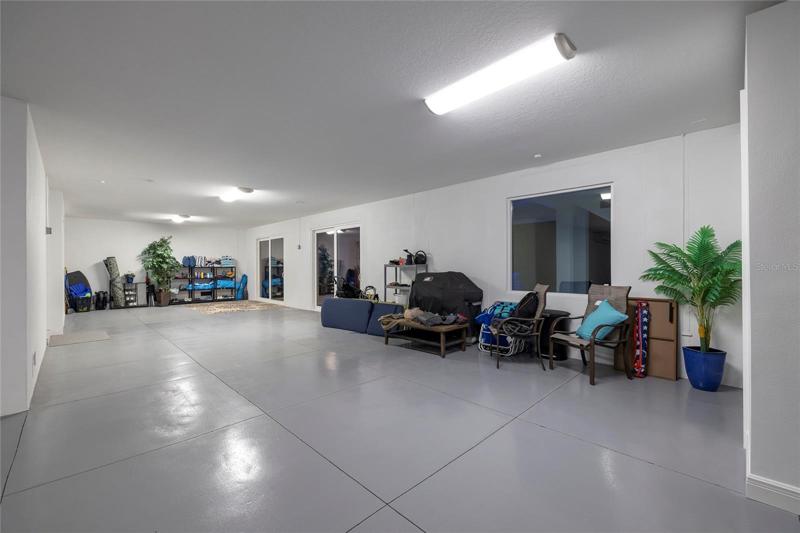 First floor garage has a double garage door with tandem spaces to accommodate up to 5 cars. Air conditioned with a mini split HVAC.  A half pool bath is located off the garage.  Space can also be used for air conditioned storage