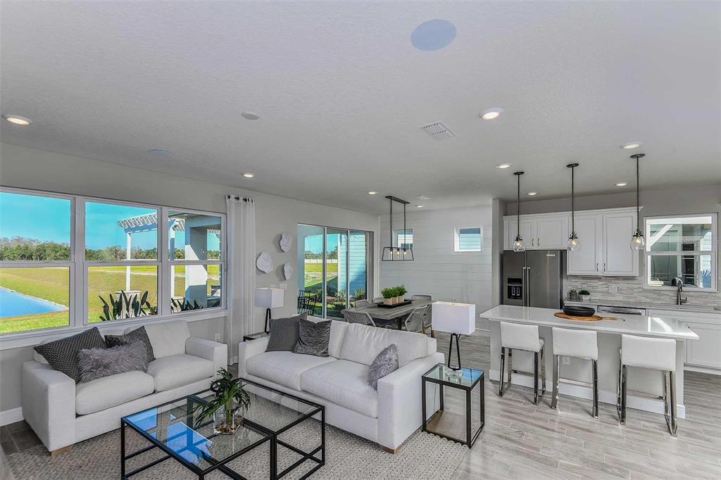 Kitchen, Gathering Room, Cafe and Covered Lanai. Model home design. Pictures are for illustration purposes only. Elevations, colors and options may vary. Furniture is for model home only.