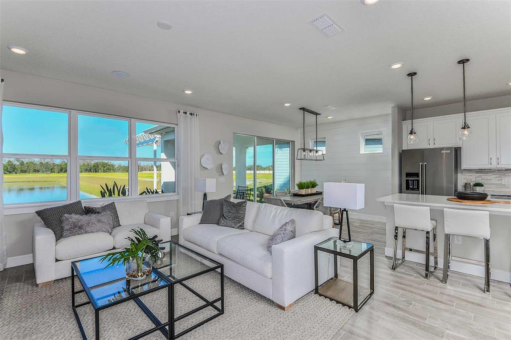 Gathering Room, Cafe and Covered Lanai. Model home design. Pictures are for illustration purposes only. Elevations, colors and options may vary. Furniture is for model home only.