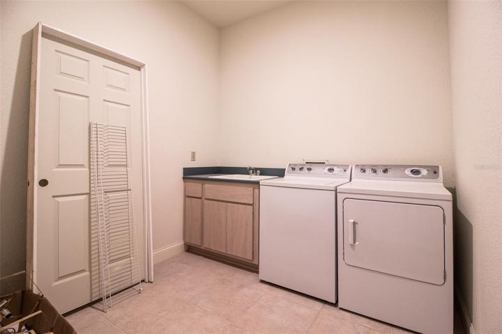 Laundry Room is spacious, and off of a hallway.  Tile floor.  Cabinet with sink.