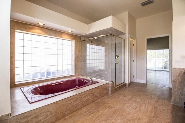 Offers a jetted soaking tub and separate shower.