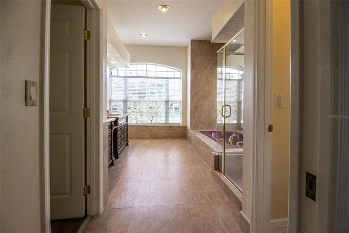 Master Bathroom with high ceilings, lots of tile and large walk-in closet.