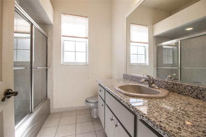 Guest bath with granite counter and shower/tub combo.