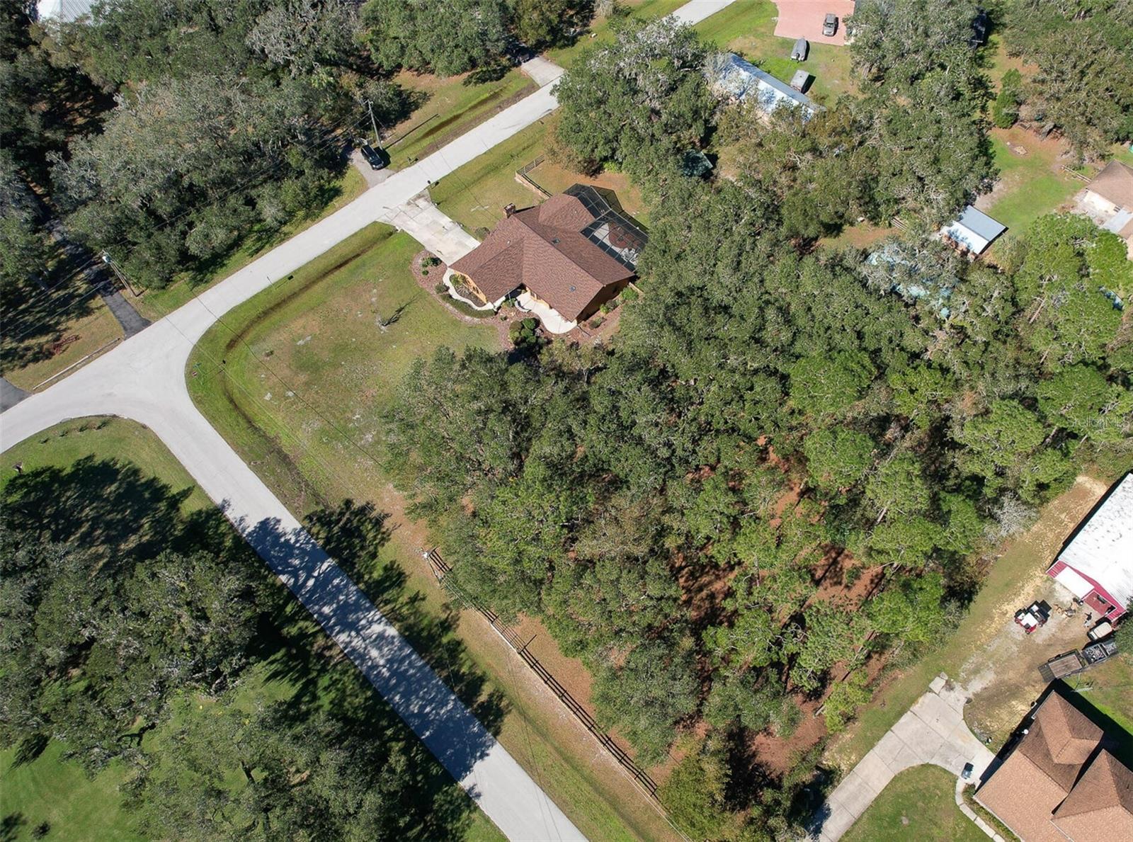Ariel View of Property. Custom Home(3 Bed/3 Bath/2 Car Garage on 2.06 acres) NEW ROOF &amp; PAINT in 2022. Not in a Flood Zone, No HOA or CDD. Huge Pole Barn, Cowboy Kitchen, Fire Pit, Potting Shed, Vacant land &amp; Huge Screened in Lanai.