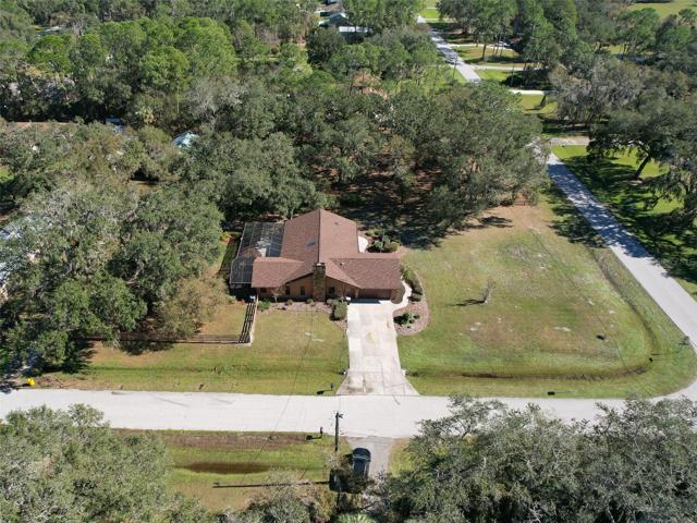 Ariel Side View of Property. Custom Home(3 Bed/3 Bath/2 Car Garage on 2.06 acres) NEW ROOF & PAINT in 2022. Not in a Flood Zone, No HOA or CDD. Huge Pole Barn, Cowboy Kitchen, Fire Pit, Potting Shed, Vacant land & Huge Screened in Lanai.