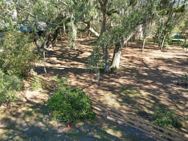 View of the beautiful, shaded, fenced, vacant one acre of land with a 40'x48