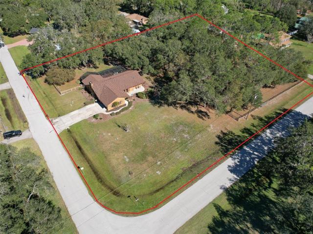 Front of Custom Home(3 Bed/3 Bath/2 Car Garage on 2.06 acres) NEW ROOF & PAINT in 2022. Not in a Flood Zone, No HOA or CDD. Huge Pole Barn, Cowboy Kitchen, Fire Pit, Potting Shed, Vacant land & Huge Screened in Lanai.