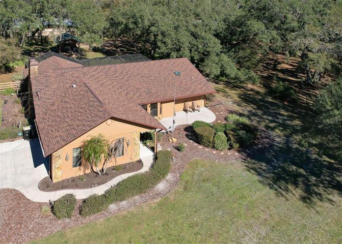 Front Ariel View of Property. Custom Home(3 Bed/3 Bath/2 Car Garage on 2.06 acres) NEW ROOF & PAINT in 2022. Not in a Flood Zone, No HOA or CDD. Huge Pole Barn, Cowboy Kitchen, Fire Pit, Potting Shed, Vacant land & Huge Screened in Lanai.