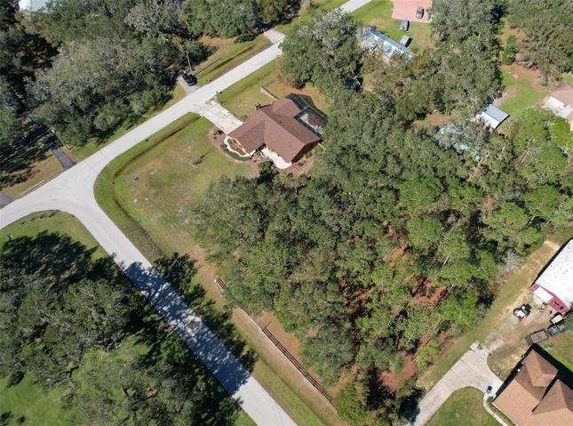 Ariel View of Property. Custom Home(3 Bed/3 Bath/2 Car Garage on 2.06 acres) NEW ROOF & PAINT in 2022. Not in a Flood Zone, No HOA or CDD. Huge Pole Barn, Cowboy Kitchen, Fire Pit, Potting Shed, Vacant land & Huge Screened in Lanai.