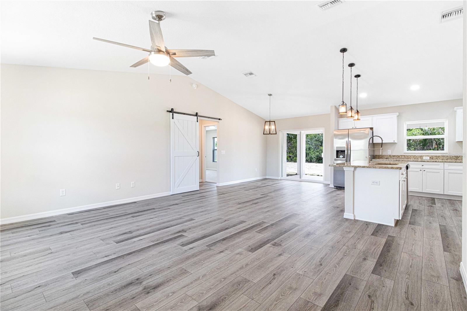 LIVING ROOM WITH BARN DOOR OFFERING PRIVACY TO MASGTER BEDROOM