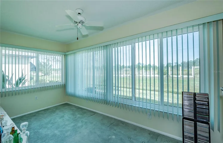 Back lanai with full wall of windows on both outside walls.  These impact windows add an abundance of light to this delightful room as well as being hurricane safe!