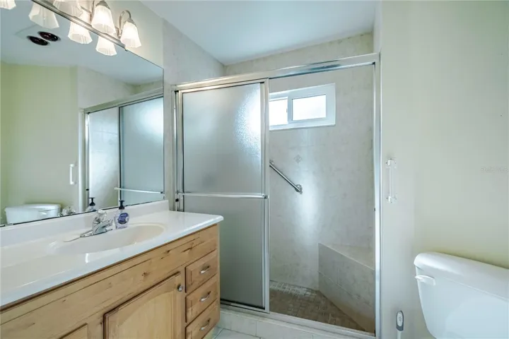 Master bathroom with stand-up shower w/a seat and handicap bars.