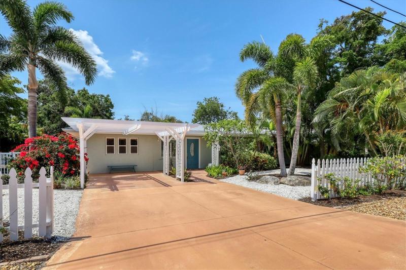 Classic ranch style home with lifetime metal roof, white picket fence, tropical landscaping and upgrades sure to please.