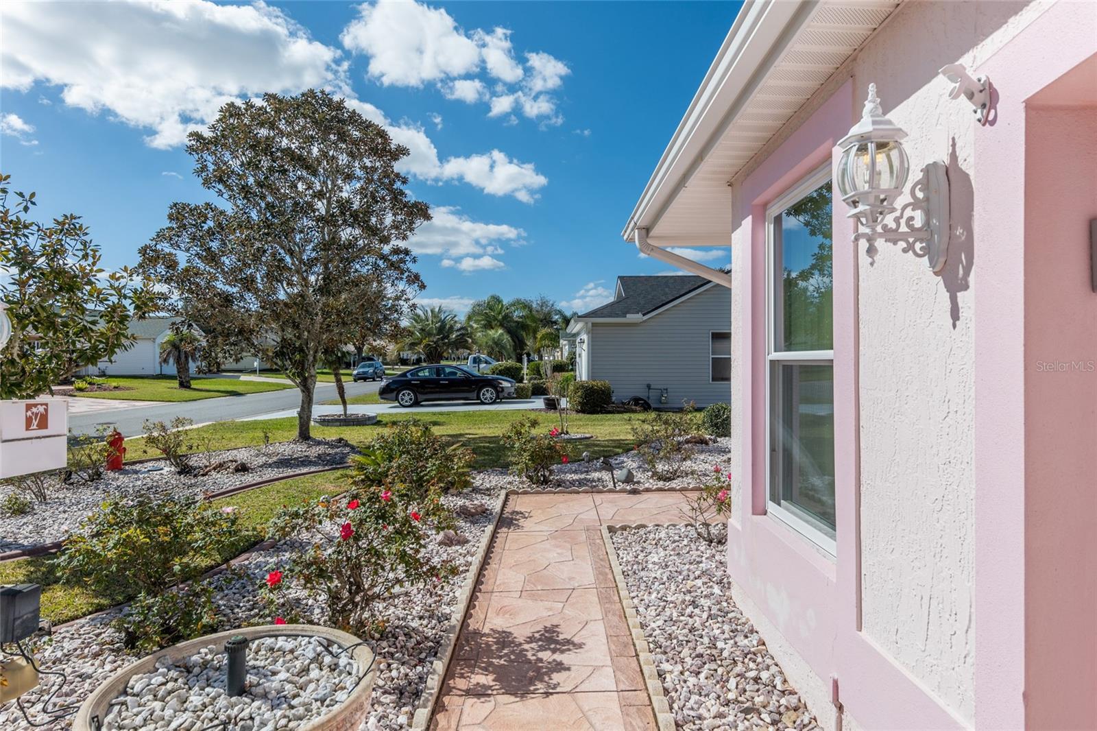 IMPRINTED CONCRETE WALKWAY to front entrance. Note ROCK FILLED landscape beds lined with CONCRETE CURBING.