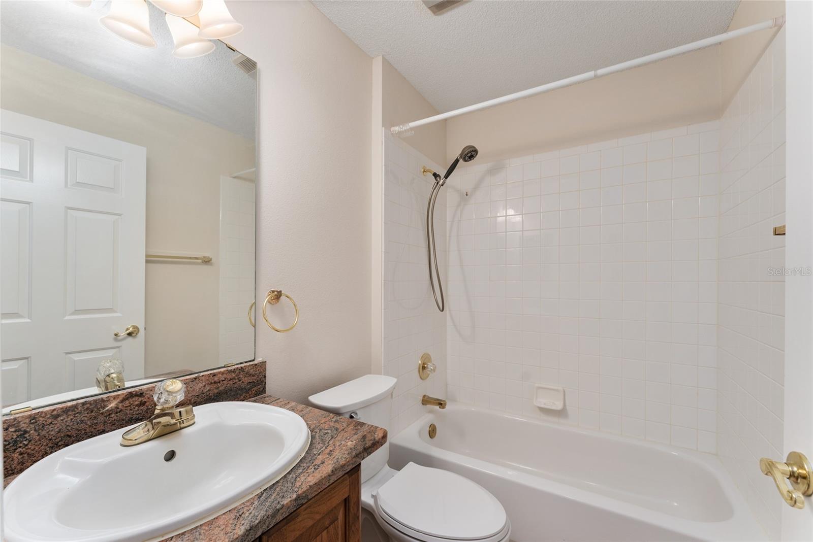BATHROOM #2 has single OAK vanity w/ matching GRANITE COUNTERTOP, TUB/SHOWER combo w/ TILED surround, and COMFORT HEIGHT TOILET