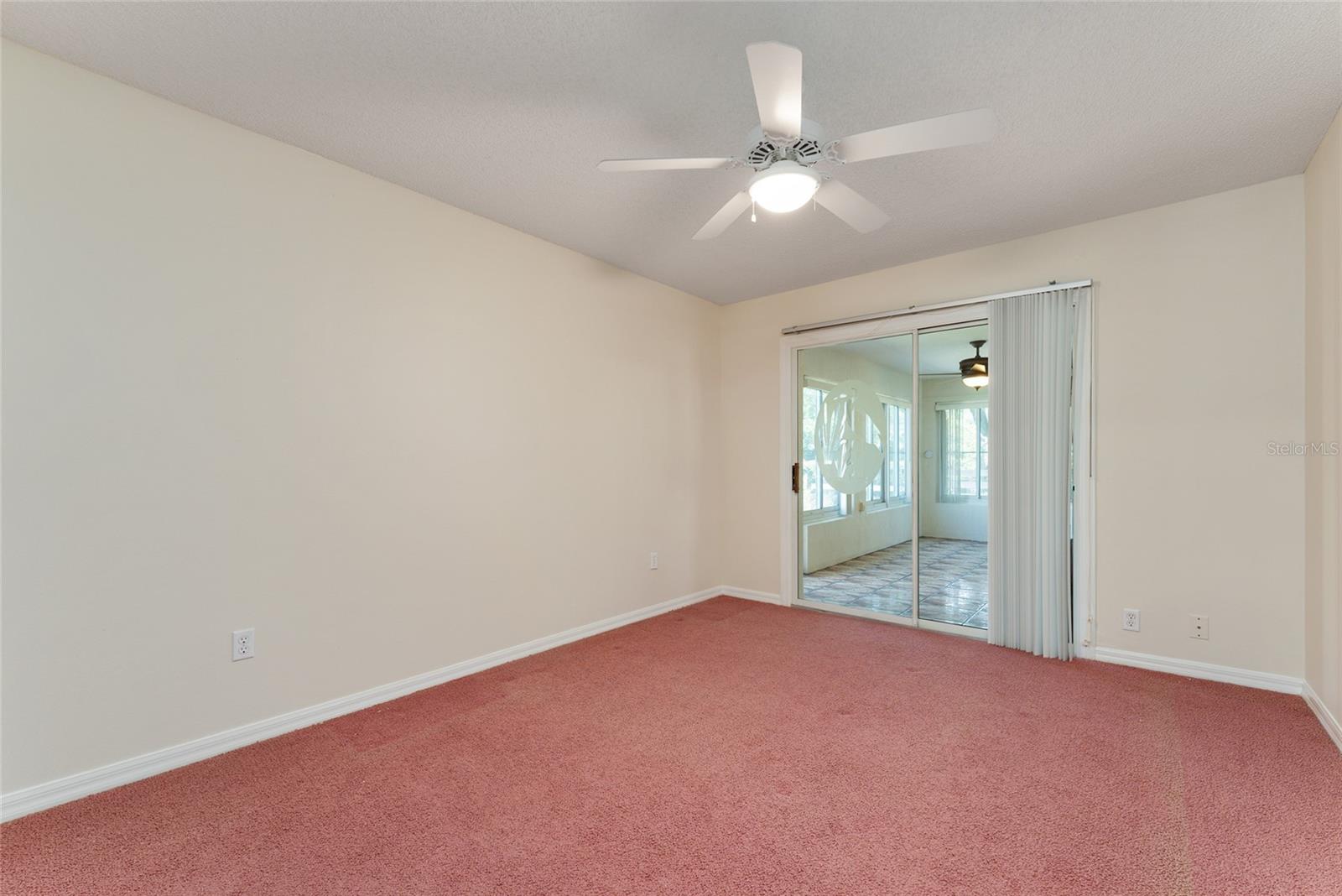 BEDROOM #2 in rear of home has SLIDING GLASS DOORS leading to PLEXIGLASS ENCLOSED LANAI w/ LEISURE ROOM area.