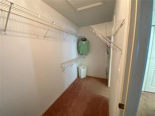 Master closet looking from the bedroom's entry door.  Light on the carpet comes in from the entry door to the bath.