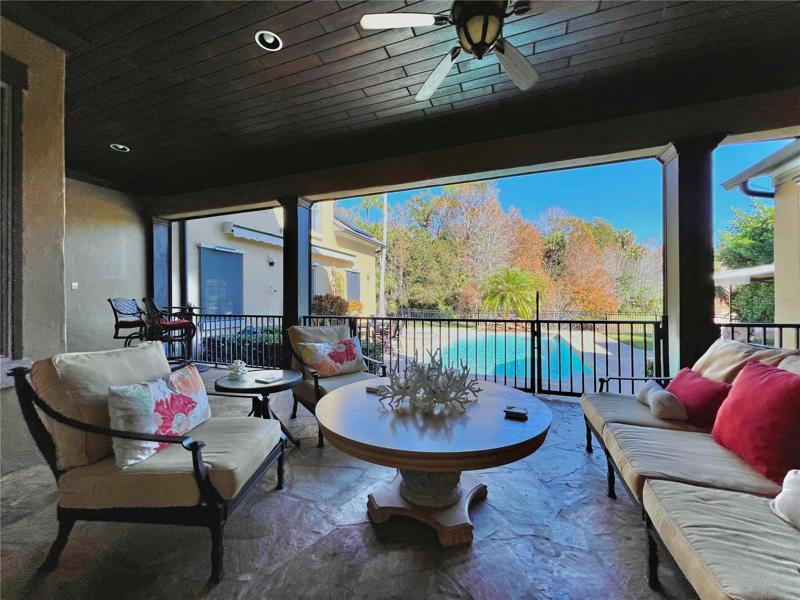 Oversized covered back patio with lake view and pool - features remote controlled screens