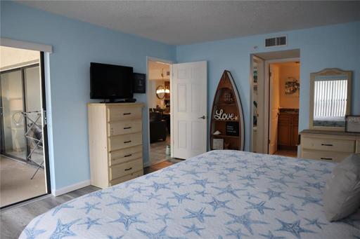 Master bedroom with balcony access, a walk in closet, and a private attached bathroom.