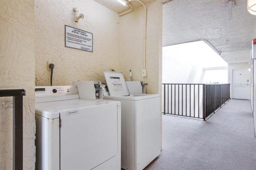 Coin operated washer and dryer on the floor.
