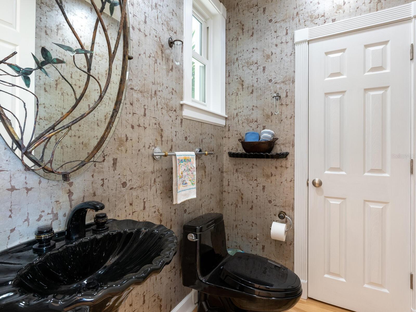 Private powder room off the foyer with a large storage closet beyond...