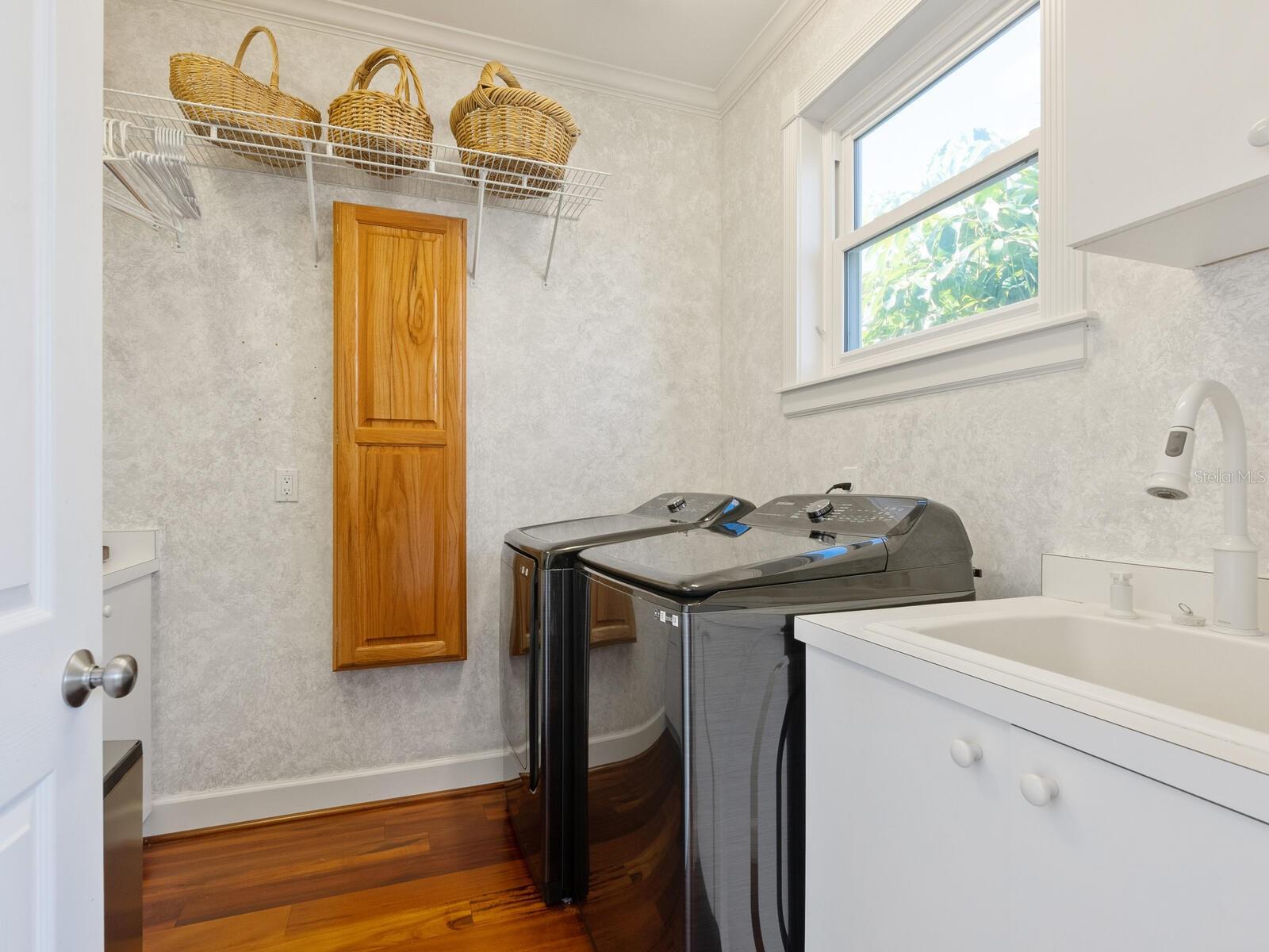 The butlers pantry / laundry room has a custom art inspired painting on the walls
