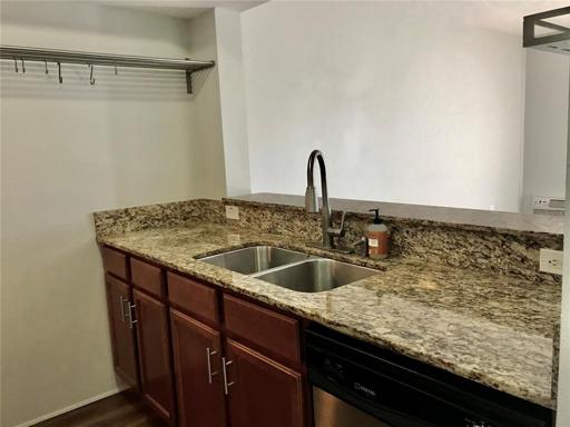 Wood cabinets, granite counters, and stainless appliances include refrigerator, range, dishwasher, and double sink with disposal. Stainless shelving and breakfast bar maximize space functionality.