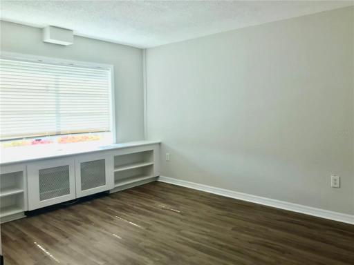 Bedroom with built-in shelving and new windows installed 2023.