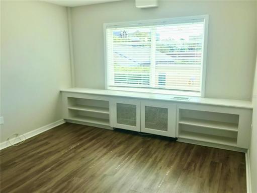 Bedroom with built-in shelving and new windows installed 2023.