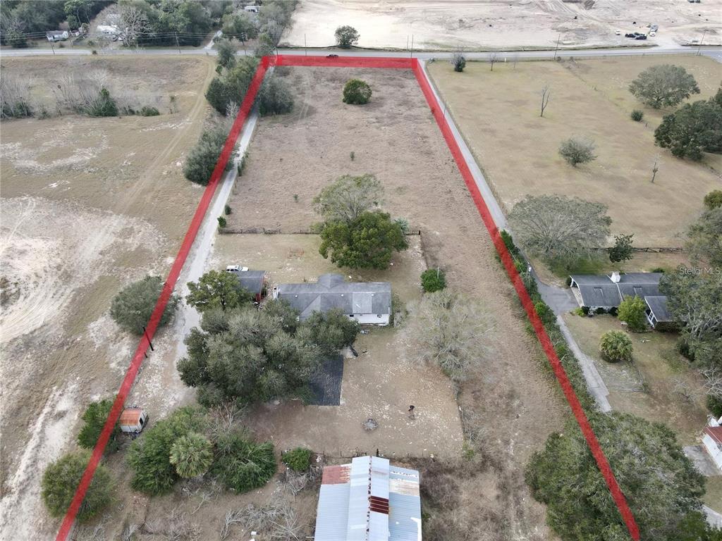Overhead view shows the paved driveway leading to the structures.