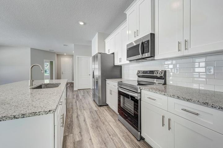 Appliances and counter space looking towards laundry room door to garage